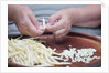 Woman selecting and separating green beans from pods by Anonymous