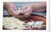 Woman selecting and separating green beans from pods by Anonymous