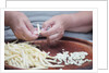 Woman selecting and separating green beans from pods by Anonymous