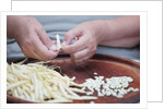 Woman selecting and separating green beans from pods by Anonymous