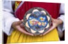 Woman holding wooden plate, China by Anonymous