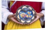 Woman holding wooden plate, China by Anonymous