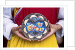 Woman holding wooden plate, China by Anonymous