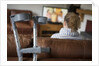 Woman watching TV with crutches by Anonymous