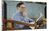Pensive Man Reading Newspaper in Living Room by Anonymous
