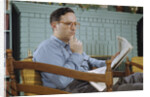 Pensive Man Reading Newspaper in Living Room by Anonymous