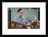 Pensive Man Reading Newspaper in Living Room by Anonymous