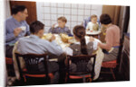 Family Eating Together at Dinner Table by Anonymous