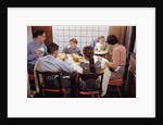 Family Eating Together at Dinner Table by Anonymous