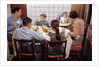 Family Eating Together at Dinner Table by Anonymous