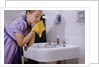 Girl Washing Her Face at Sink by Anonymous