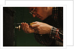 Man Fixing Knob on Screen Door by Anonymous