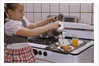 Girl Preparing Breakfast in Kitchen by Anonymous