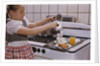 Girl Preparing Breakfast in Kitchen by Anonymous