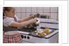 Girl Preparing Breakfast in Kitchen by Anonymous