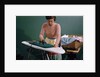 Woman Ironing at Home by Anonymous