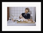 Woman Decorating Cup Cakes by Anonymous