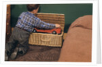 Boy Removing Fire Engine from Toy Chest by Anonymous