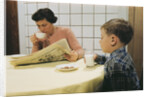 Boy Eating Cookies and Milk as Mom Reads by Anonymous