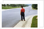 Boy Waiting on Suburban Street by Anonymous