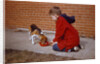 Boy Feeding Dog on Sidewalk by Anonymous