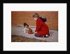 Boy Feeding Dog on Sidewalk by Anonymous