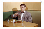 Businessman Pouring Syrup on Pancakes by Corbis