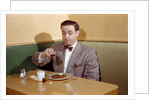 Businessman Pouring Syrup on Pancakes by Corbis