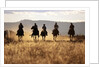 Cowboys Galloping Horses in Field by Anonymous