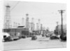 Clusters Of Oil Derricks Along Street by Anonymous