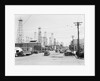 Clusters Of Oil Derricks Along Street by Anonymous