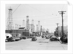 Clusters Of Oil Derricks Along Street by Anonymous