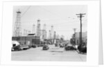 Clusters Of Oil Derricks Along Street by Anonymous