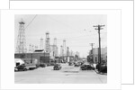 Clusters Of Oil Derricks Along Street by Anonymous