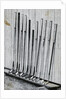 Variety Of Golf Clubs Lean Against Wall by Anonymous
