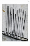Variety Of Golf Clubs Lean Against Wall by Anonymous