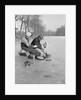 Man Puts Ice Skates On Woman At Rink by Anonymous