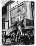 Woman Sitting on Luggage Trolley by Anonymous