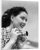 Woman Smiles as She Holds Camera by Anonymous