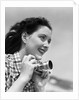 Woman Smiles as She Holds Camera by Anonymous