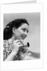Woman Smiles as She Holds Camera by Anonymous