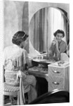 Young Woman Applying Face Cream at Vanity by Anonymous