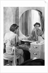 Young Woman Applying Face Cream at Vanity by Anonymous