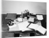 Desk Covered with Assorted Office Supplies by Anonymous
