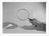 Hand Holding a Magnifying Glass by Anonymous