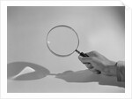 Hand Holding a Magnifying Glass by Anonymous