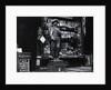 Wooden Statue In Front Of Shop Window by Anonymous