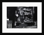 Wooden Statue In Front Of Shop Window by Anonymous