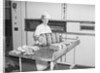 Man Taking Bread Loaves from Oven by Anonymous