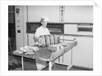 Man Taking Bread Loaves from Oven by Anonymous